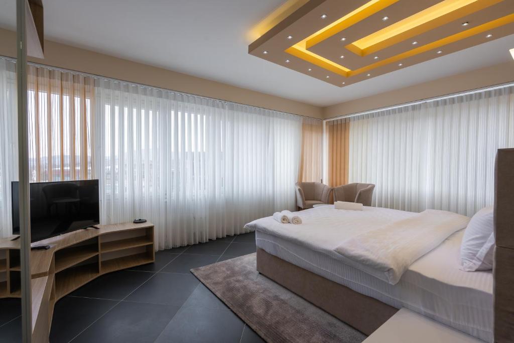 斯科普里Hotel & Resort Bon Bon的一间卧室配有一张床和一台平面电视