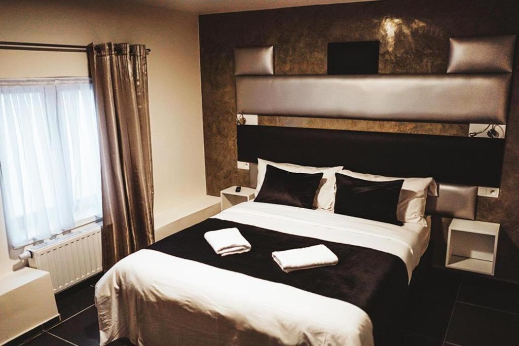 布鲁塞尔Hôtel onyx expo的一间卧室配有一张大床和两条毛巾