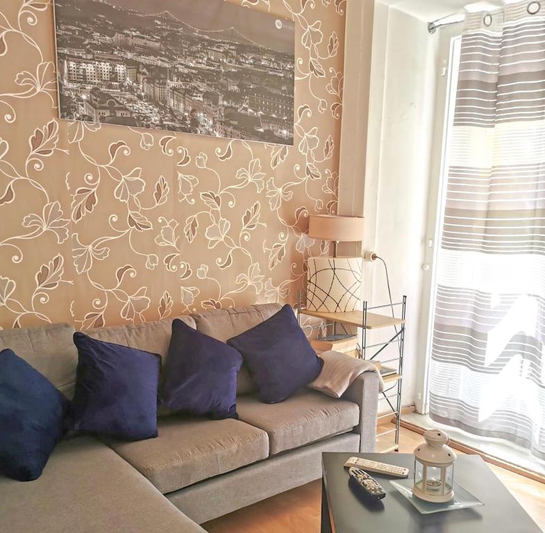 里斯本卢斯索里亚诺公寓的客厅配有带紫色枕头的沙发