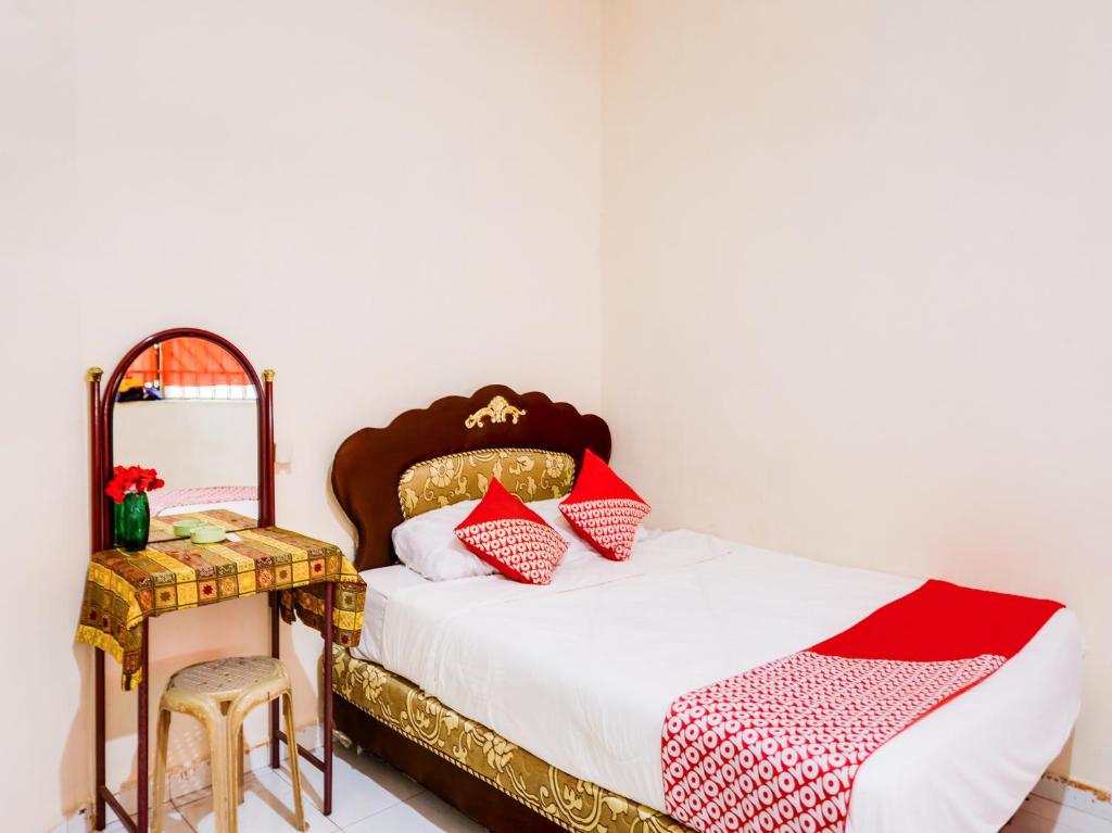 JodohSPOT ON 91512 Siantan Anambas Syariah的一间卧室配有一张床、一张桌子和一面镜子