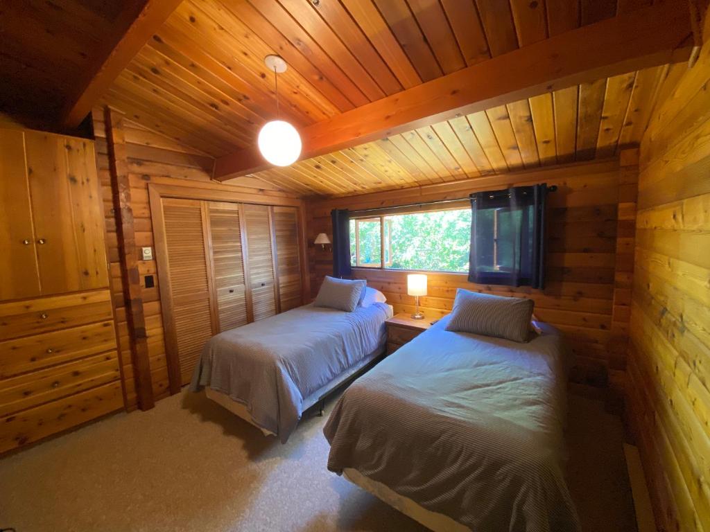 Quathiaski CoveApril Point Harbour House的小木屋内一间卧室,配有两张床