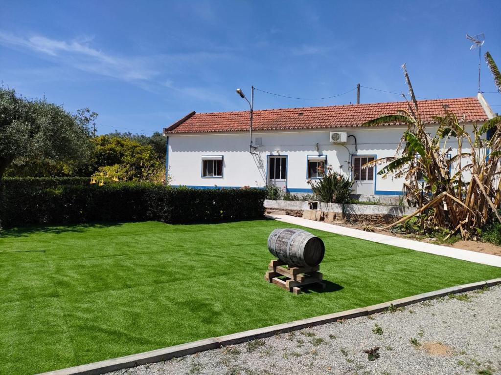 圣地亚哥-杜卡森Monte da Vinha Nova的院子内有带桶的草坪的房子