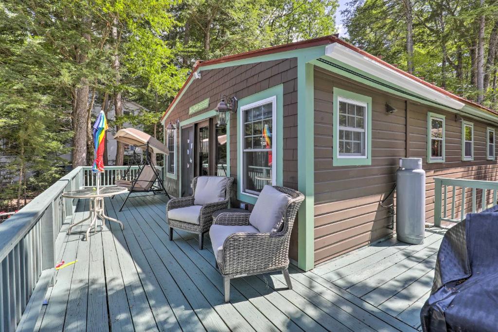 SanborntonLake Hermit Cabin with Kayaks and Paddleboards!的小屋设有2把椅子和1张桌子,位于甲板上