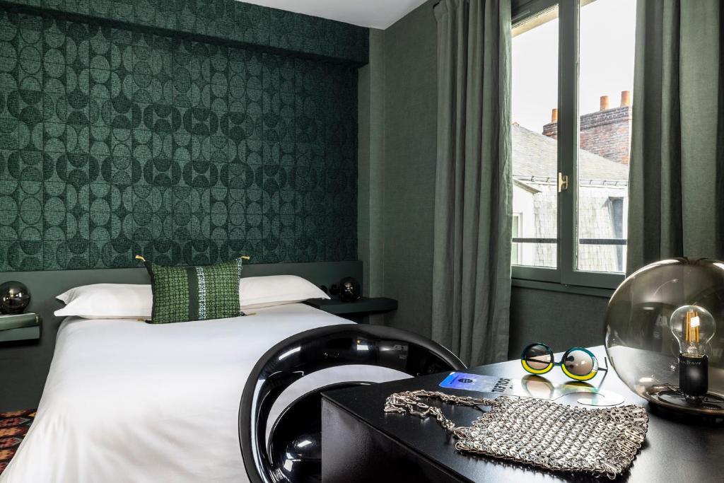 南特L酒店的一间卧室配有一张床、一张书桌和一个窗户。