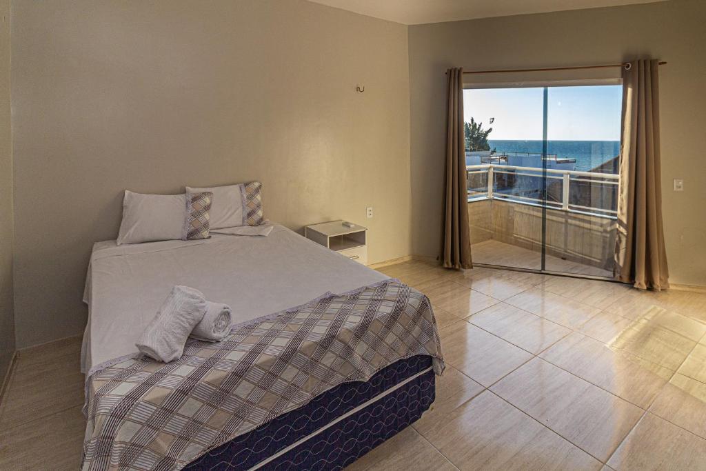 普雷亚Praieiro pousada的一间卧室配有一张床,享有海景
