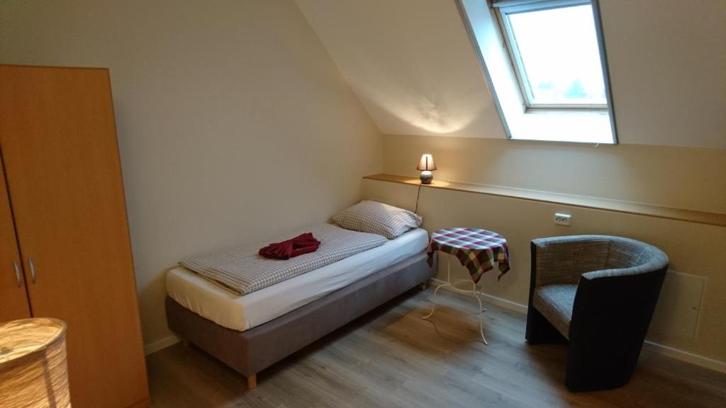 舍讷费尔德Gasthaus Zur Hecke的一间小卧室,配有一张床和一把椅子