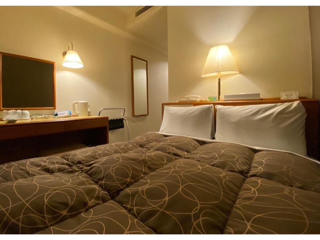 福井Az Inn Fukui - Vacation STAY 65940v的一间卧室配有一张床、一张书桌和一台电视