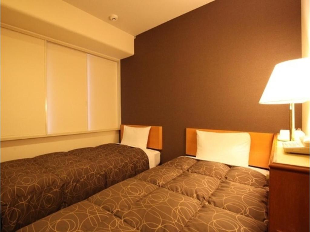 福井Az Inn Fukui - Vacation STAY 65944v的酒店客房,设有两张床和一盏灯