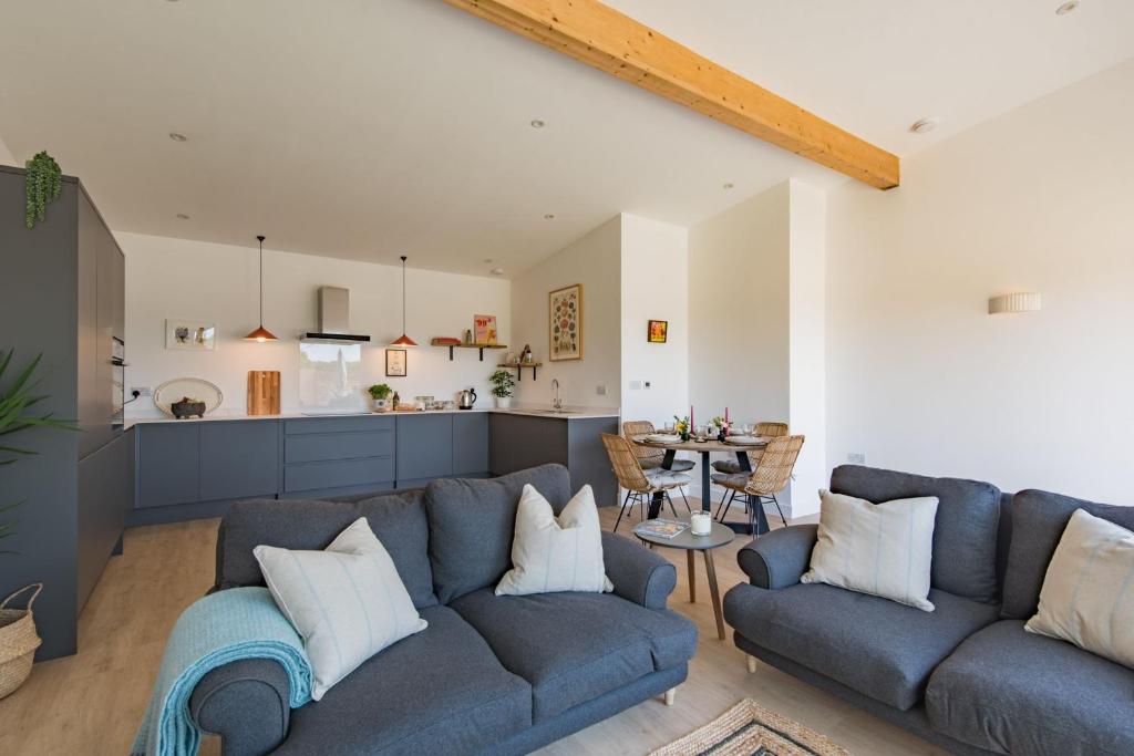 StalisfieldThe Parlour by Bloom Stays的一间带2张蓝色沙发的客厅和一间厨房