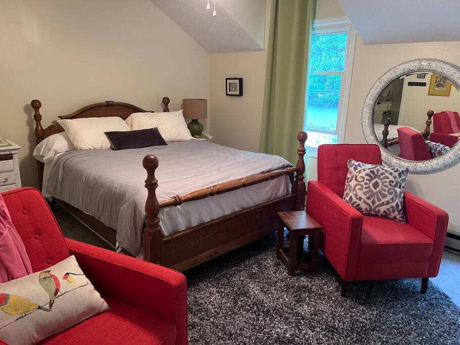 NewlandCentrally Located Resort in The High Country RELAX的一间卧室配有一张床、两把椅子和镜子