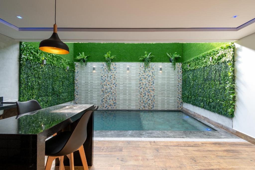 马瑙斯Drops Motel Manaus的一座室内游泳池,里面设有绿墙,种植了植物