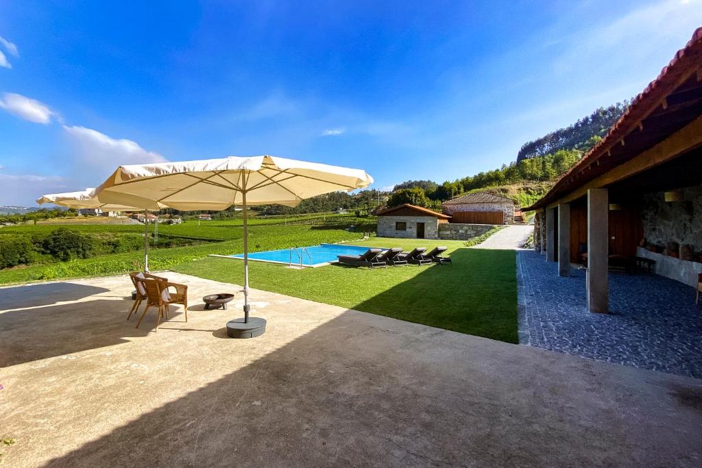 费尔盖拉什The FarmHouse II - Uma quinta deslumbrante的一个带遮阳伞和游泳池的庭院