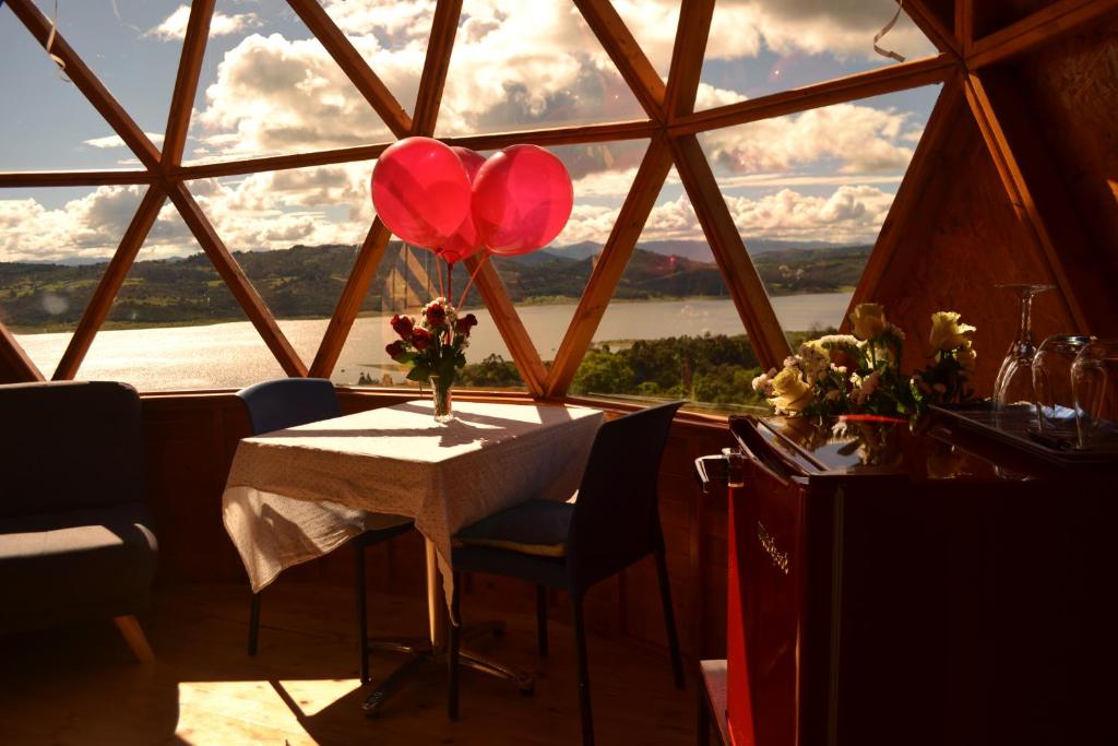 瓜塔维塔Arrecife Glamping的窗前有两个红色气球的桌子