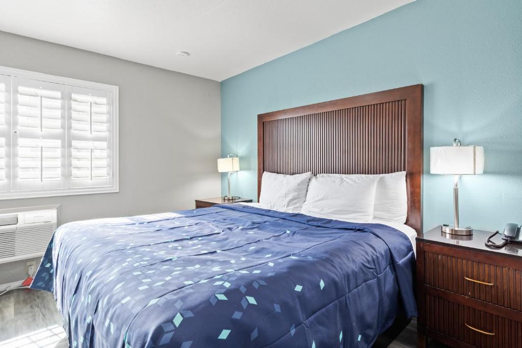 梅德福Travelers Inn Medford I-5的一间卧室配有一张带蓝色毯子的大床
