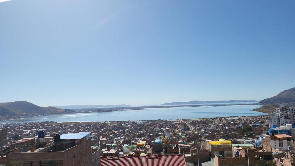 普诺Departamento 3 niveles- Vista Panoramica 360 grados a toda la ciudad y Lago Titicaca的城市和水体的空中景观