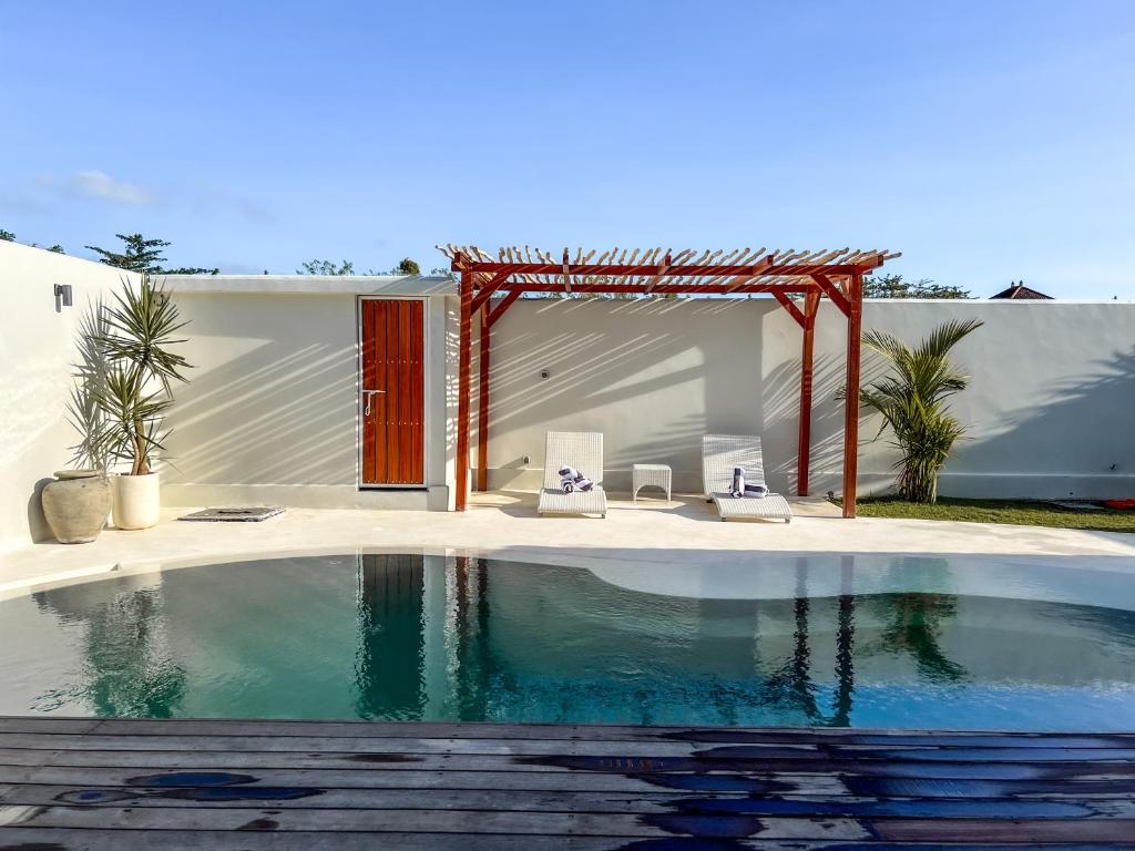 乌鲁瓦图Moana Villa & Suites Bingin的一座带凉亭的房子前的游泳池