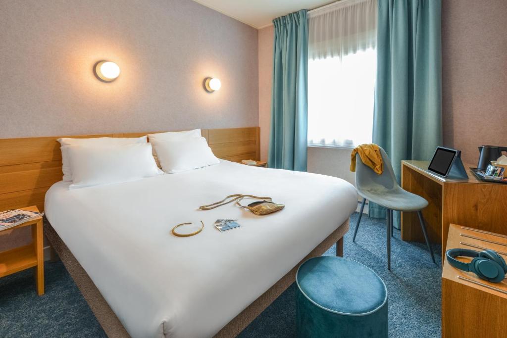 博讷Sure Hotel by Best Western Centre Beaune的酒店客房设有一张白色大床和椅子