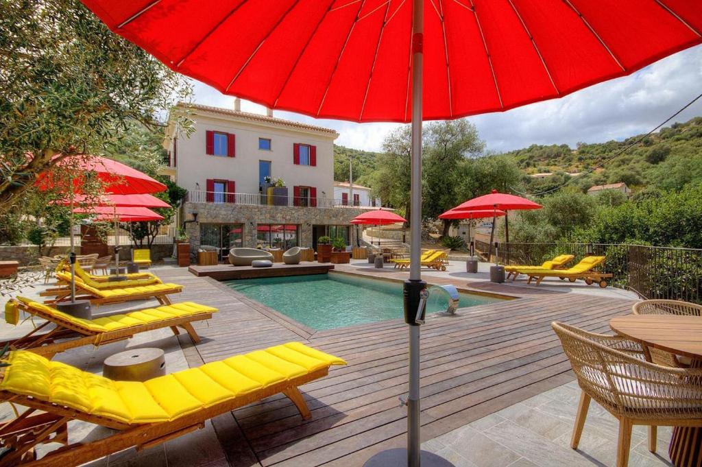 Hôtel Casale Olmia的一个带黄色椅子和红色遮阳伞的游泳池