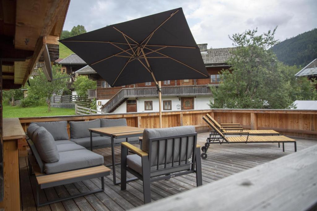 阿尔卑巴赫Ferienwohnung Kast'l的庭院配有桌椅和遮阳伞。