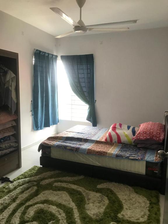 万挠Homestay Ar Rayyan RESIDENSI LAGUNA BIRU的一间卧室配有一张带窗户和地毯的床