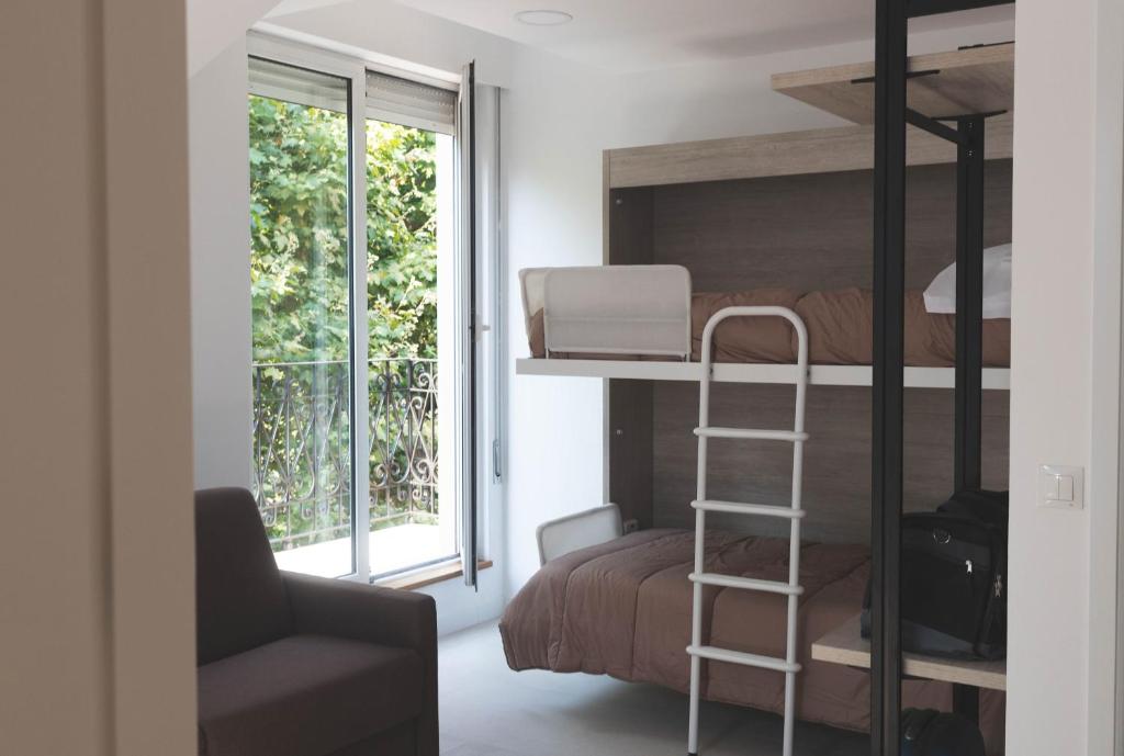 桑坦德Hostel Villa Miguela的一间卧室配有双层床、椅子和窗户。