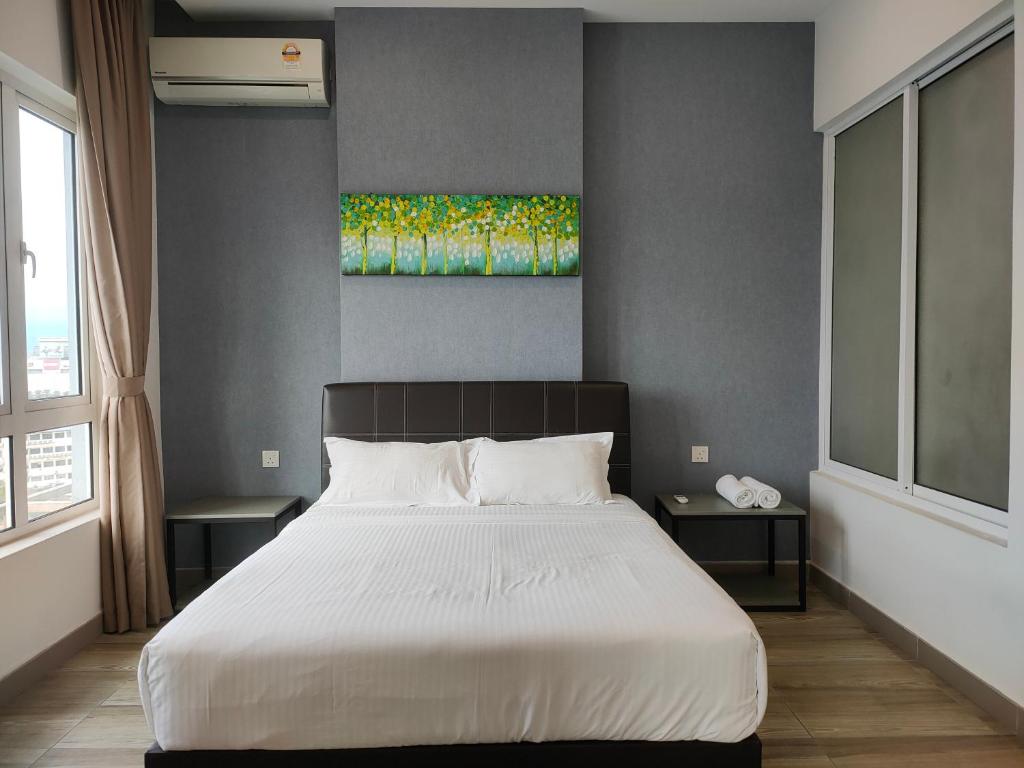 怡保八角形怡保公寓的卧室配有一张床,墙上挂有绘画作品