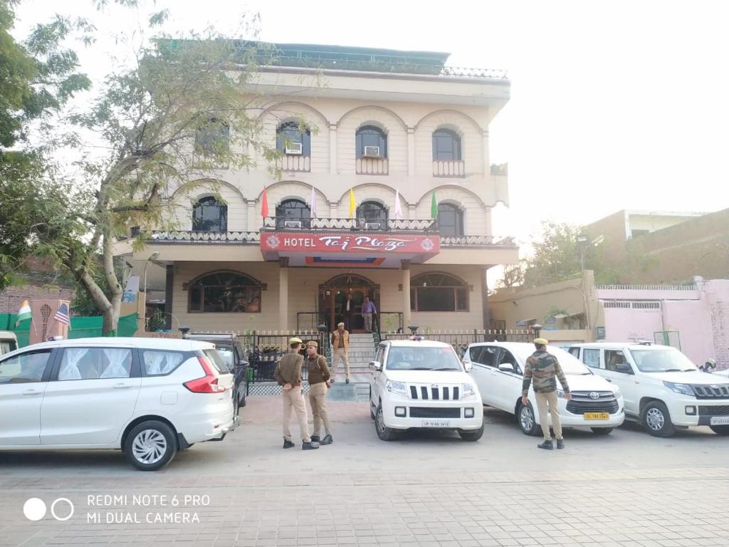 阿格拉Hotel Taj Plaza, VIP Road, Agra的停在大楼前的一组汽车