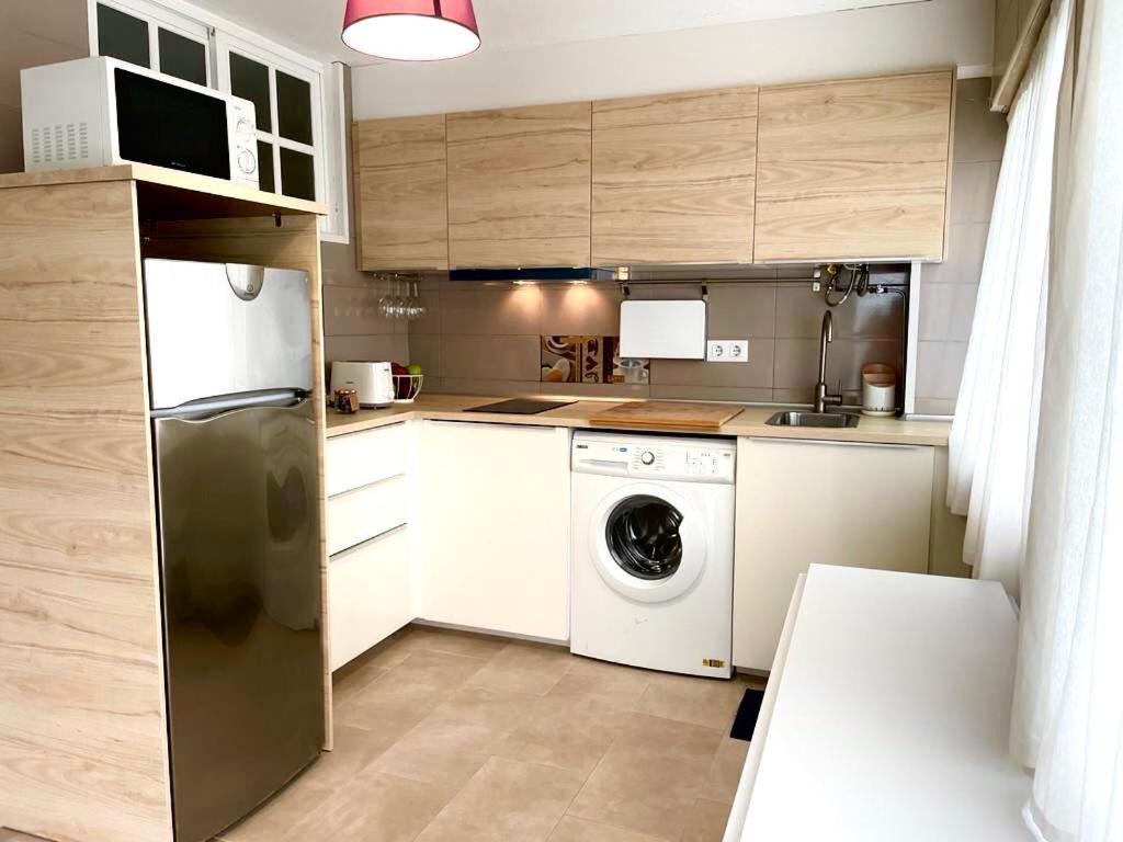 塞埃APARTAMENTO PLAYA DE ESTORDE的厨房配有冰箱、洗衣机和烘干机