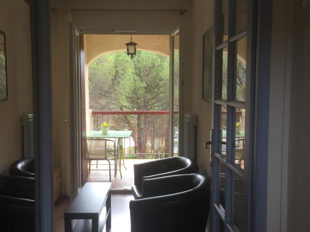 格雷乌莱班Le Clos des Oliviers的走廊上设有桌椅和窗户