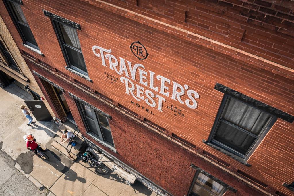 匹兹堡Traveler's Rest Hotel的红砖建筑,上面有标志,上面写着运动员抵制的标志