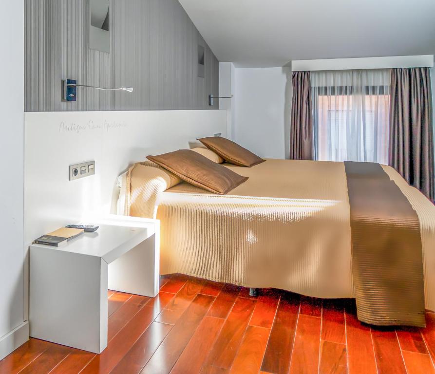 索里亚Hotel Apolonia Soria的一间卧室配有一张大床和一张桌子