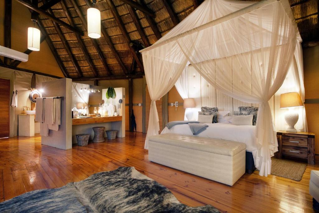 阿马卡拉保护区Bush Lodge – Amakhala Game Reserve的一间卧室配有一张带天蓬的床