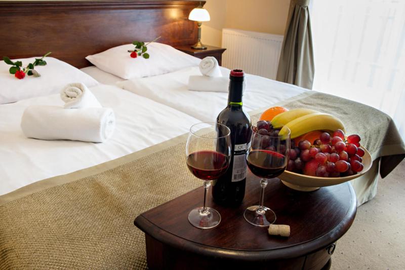 卡尔帕奇卡门酒店的一张桌子,上面放着两杯葡萄酒和一碗水果