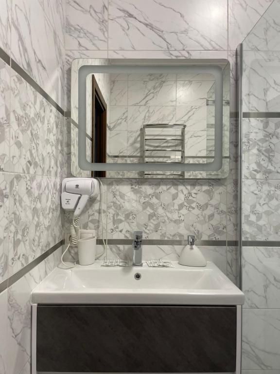 利沃夫Львівський的浴室设有白色水槽和镜子