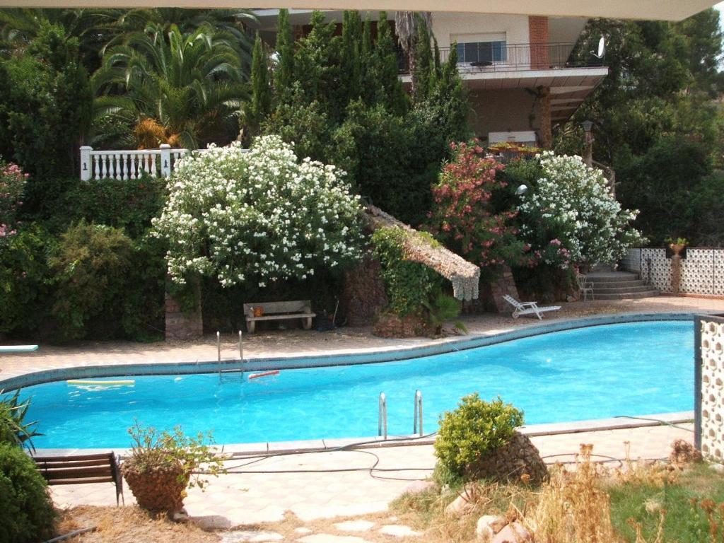 SerraCasa Rural Porta Del Cel的一座鲜花庭院里的大型蓝色游泳池