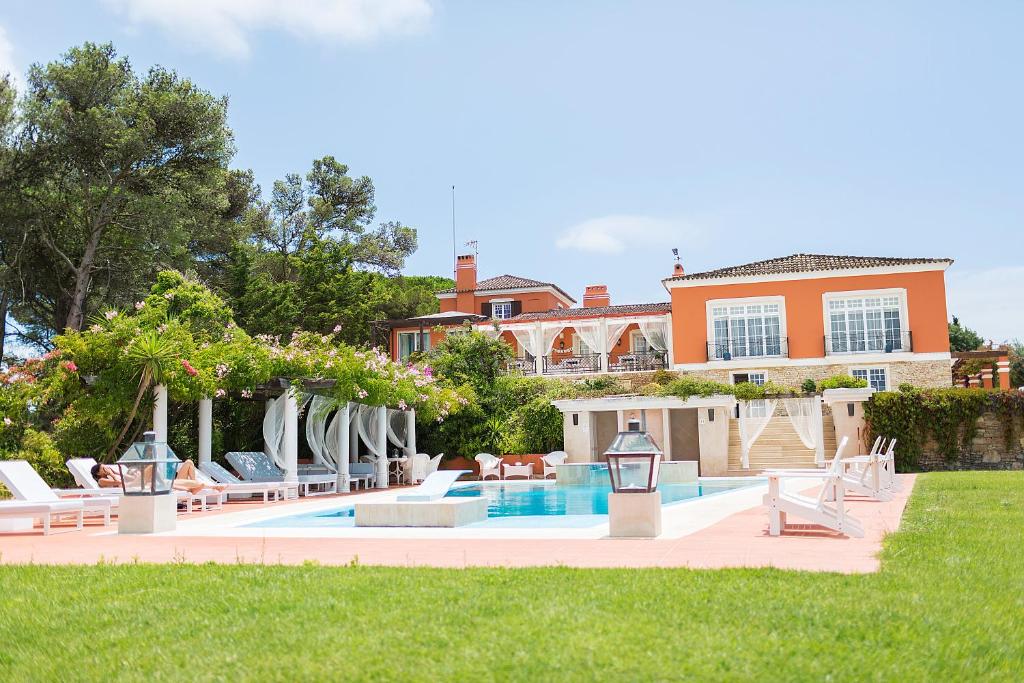 卡帕里卡海岸Quinta Tagus的一个带椅子的游泳池以及一座房子