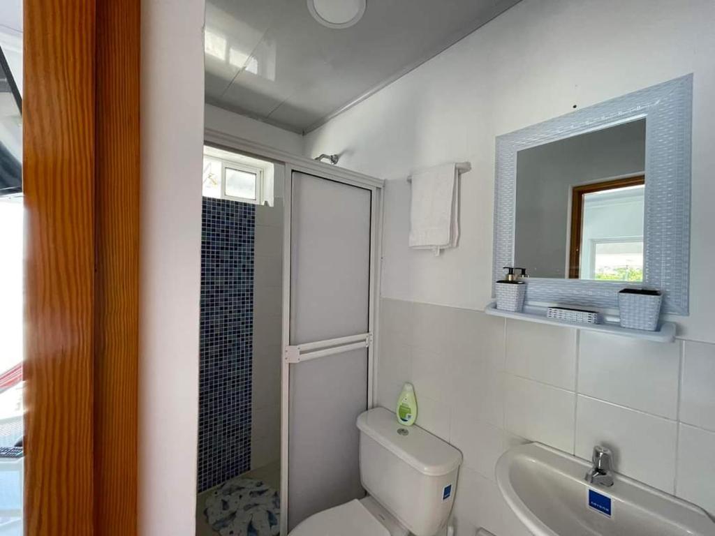 普罗维登西亚Posada Old Town Bay的一间带卫生间、水槽和镜子的浴室