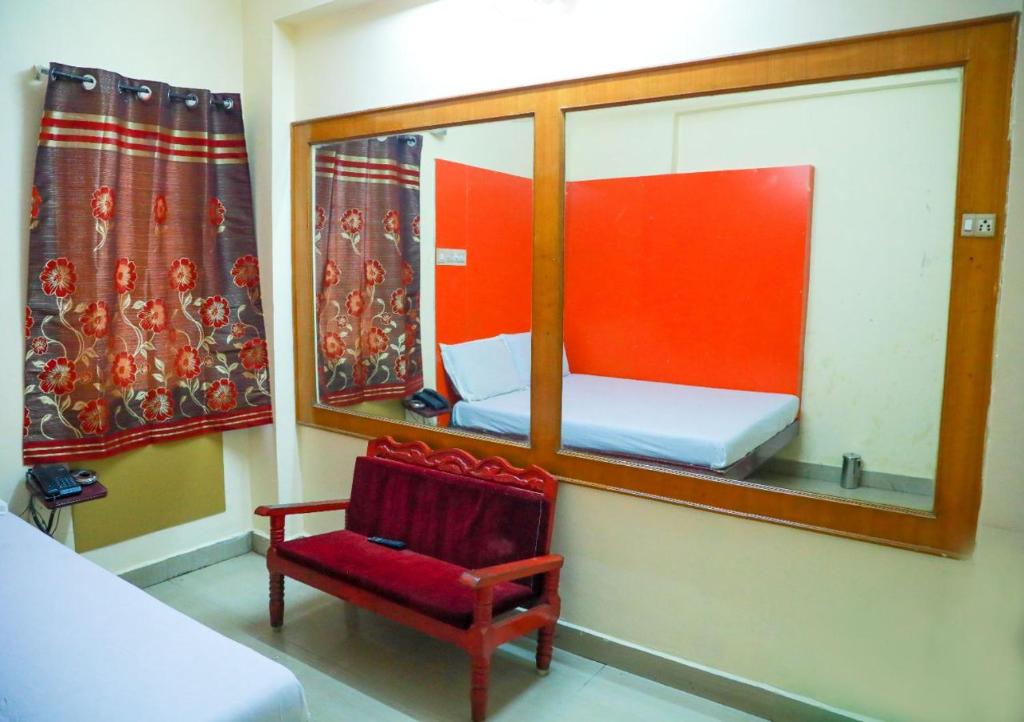 马杜赖Hotel New West Tower的小房间设有镜子和红色椅子