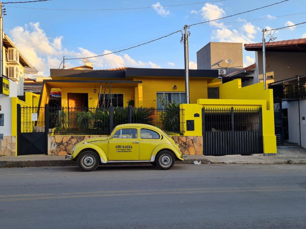 卡皮托利乌HOSTEL BADULACK的停在黄色房子前面的黄色汽车