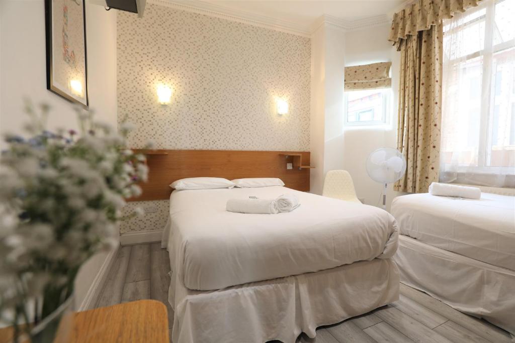 伦敦Anchor Guest House的酒店客房带两张床和花瓶