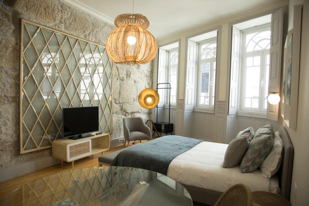波尔图TOP Porto的一间卧室配有一张床、一台电视和吊灯。