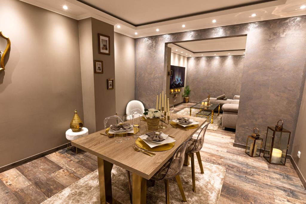 奥尔泽姆Dynasty Home Spa Appartement 100M Jacuzzi Terasse的一间带桌子和沙发的用餐室