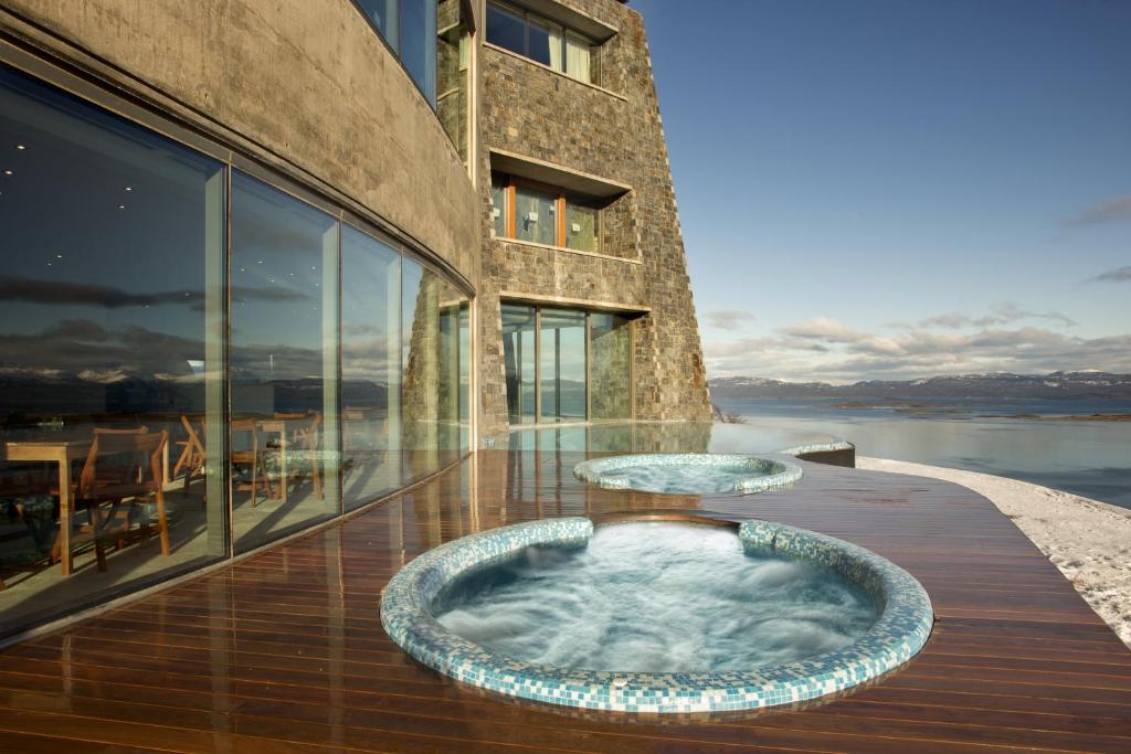 乌斯怀亚乌斯怀亚阿拉酷度假酒店暨Spa的大楼前甲板上的热水浴池