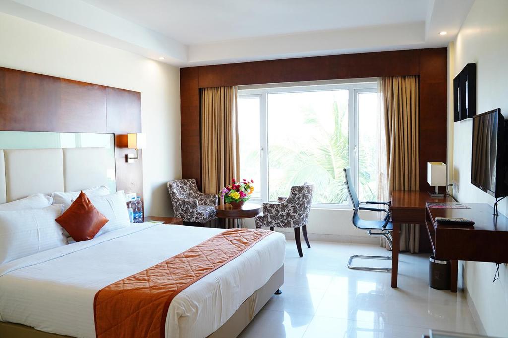 库姆巴科纳姆维哈品质酒店的酒店客房配有一张床、一张书桌和一台电脑