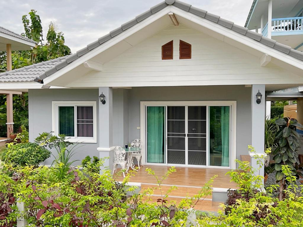 Ban Chak PhaiNew Home Gบ้านเดี่ยวสร้างใหม่ ใกล้ทะเล ตัวเมืองระยอง的一个带门廊和庭院的房子