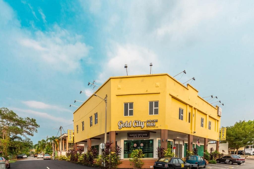 马六甲Gold City Hotel的街道边的黄色建筑