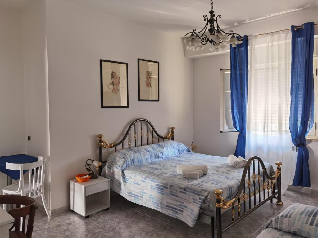 斯卡莱阿Rosy house的一间卧室配有一张带蓝色窗帘和吊灯的床。