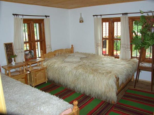 YakovtsiВила Любима的一间卧室配有一张大床和一张大型白色棉被