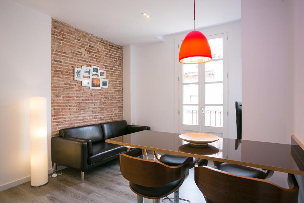 巴塞罗那Decô Apartments Barcelona-Sants的一间带桌子和皮革椅子的用餐室