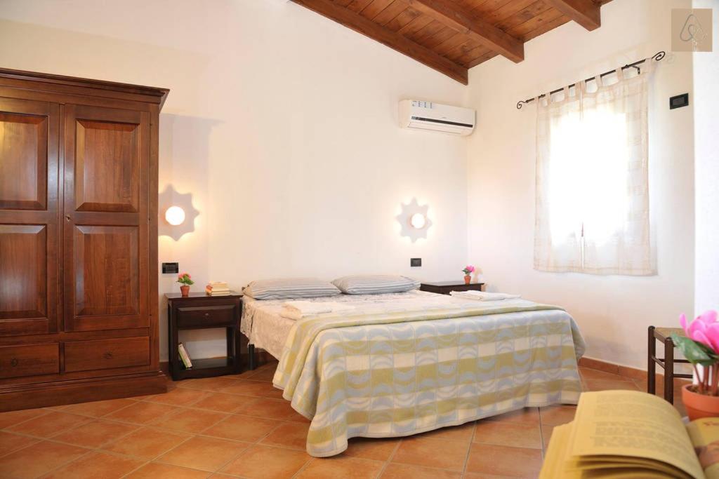 多尔加利笛多尼阿格利图里斯姆酒店的一间卧室,卧室内配有一张大床